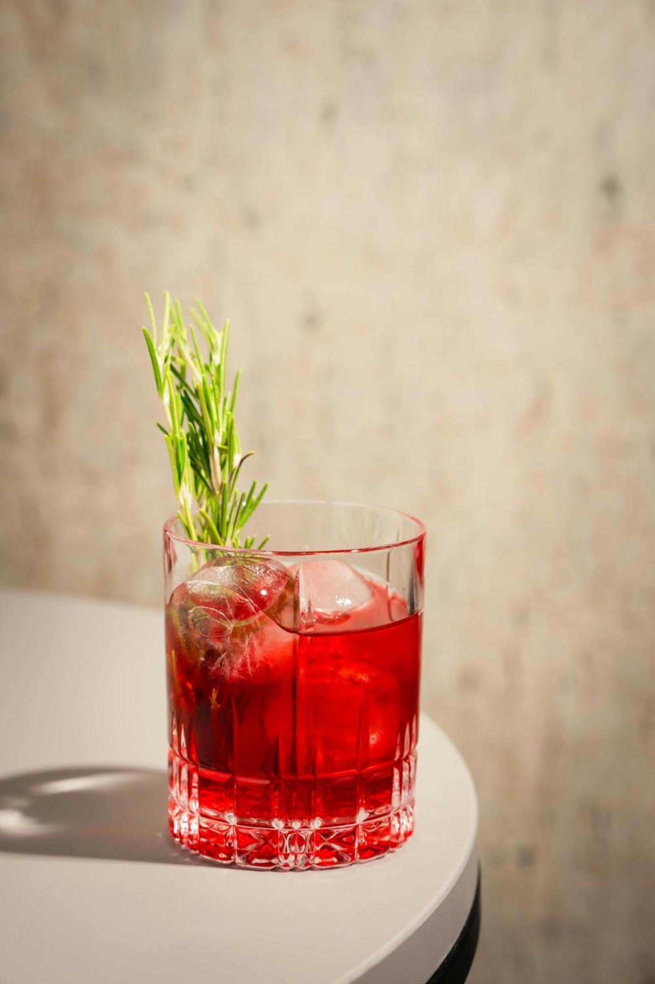 Renaissance Hamburg Hotel Kültér fotó A Negroni garnished with a sprig of rosemary